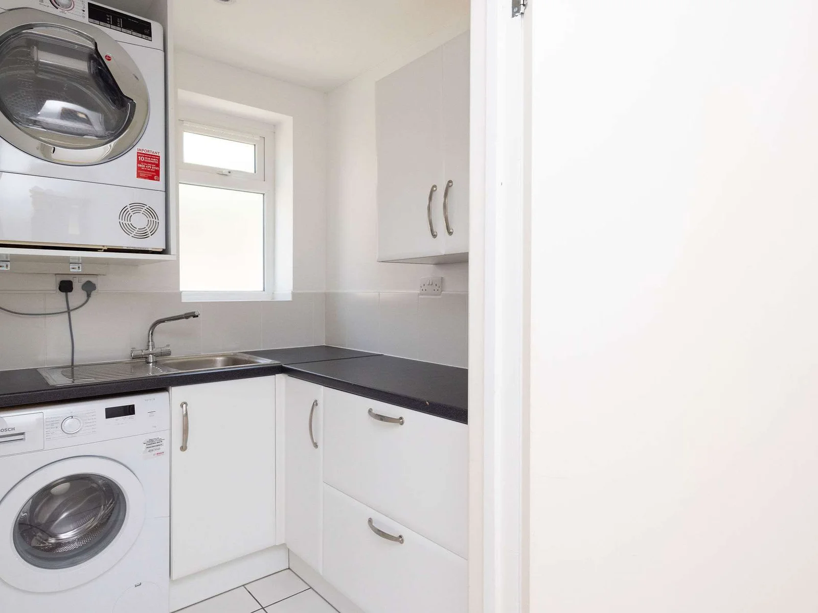 Handy utility space with washing machine, dryer, sink and storage