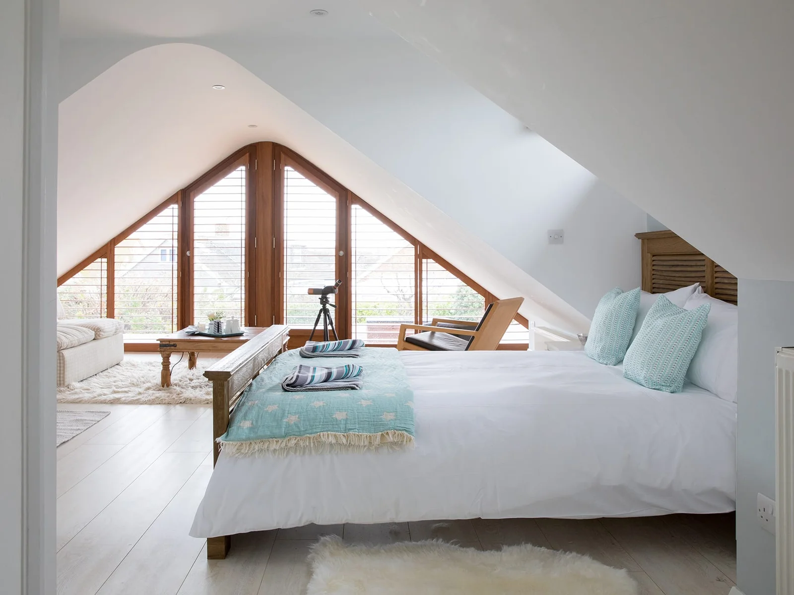 Let's start at the Master Bedroom on the upper floor! Its complete glass gable end allows you to marvel at the beautiful sunrise while sipping your morning coffee