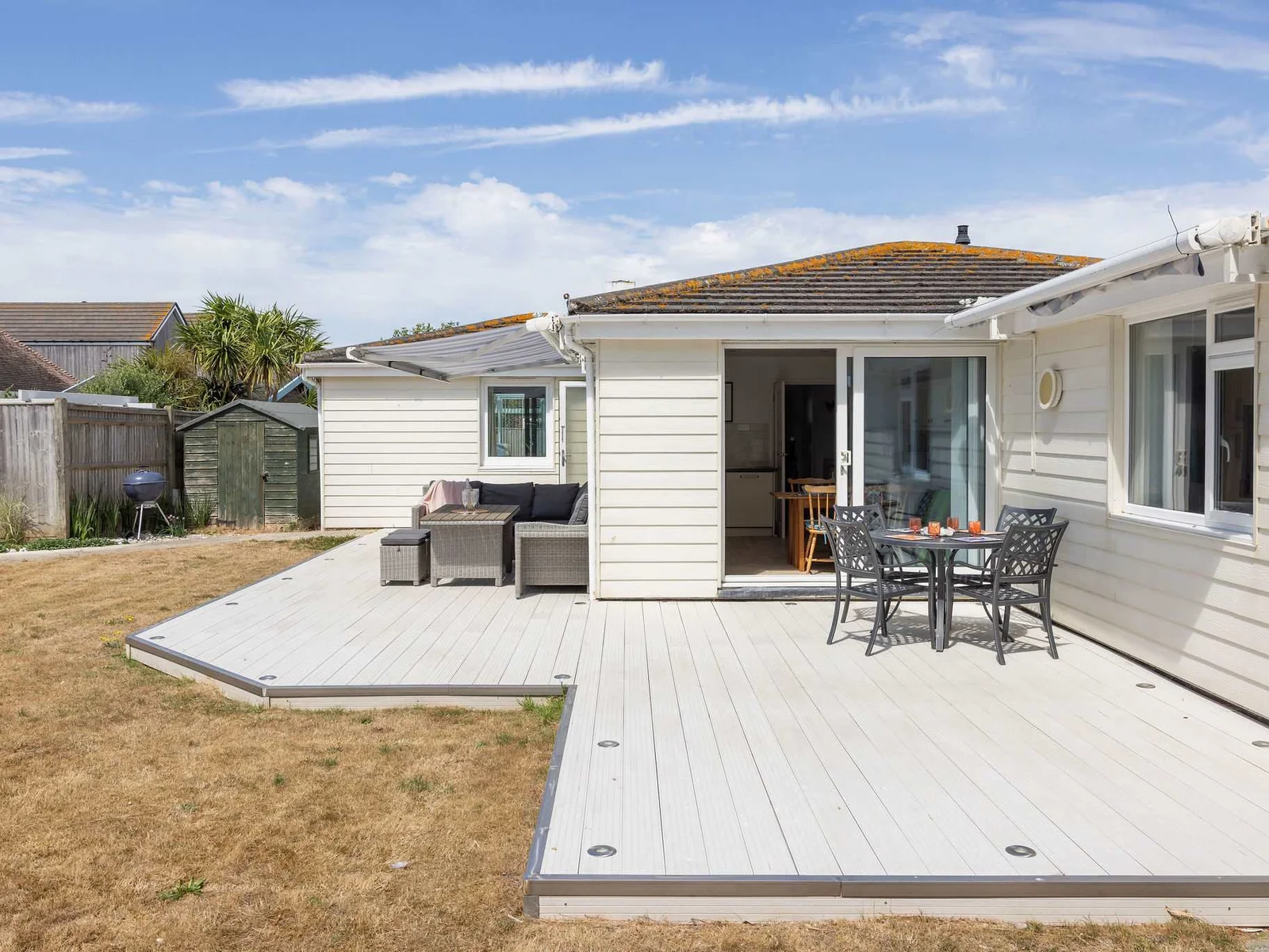 Large wraparound decking with outdoor dining and lounge areas