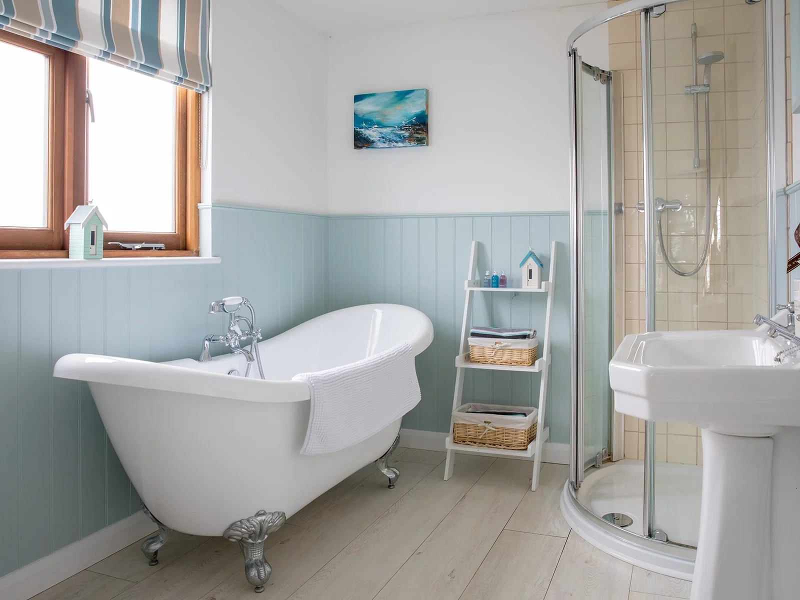 The first floor bathroom offers a vintage free-standing bathtub and a modern shower cabin.