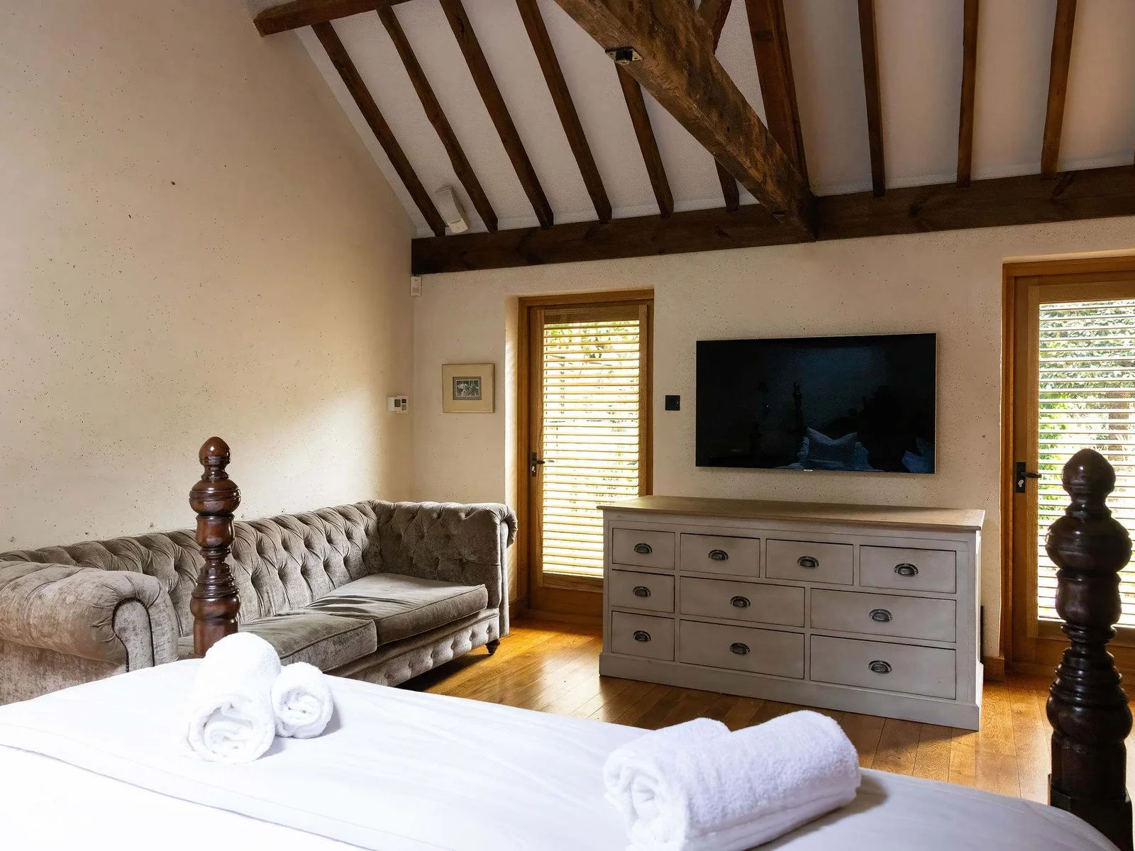 The master suite also includes a comfortable seating area, TV and generous en-suite bathroom.