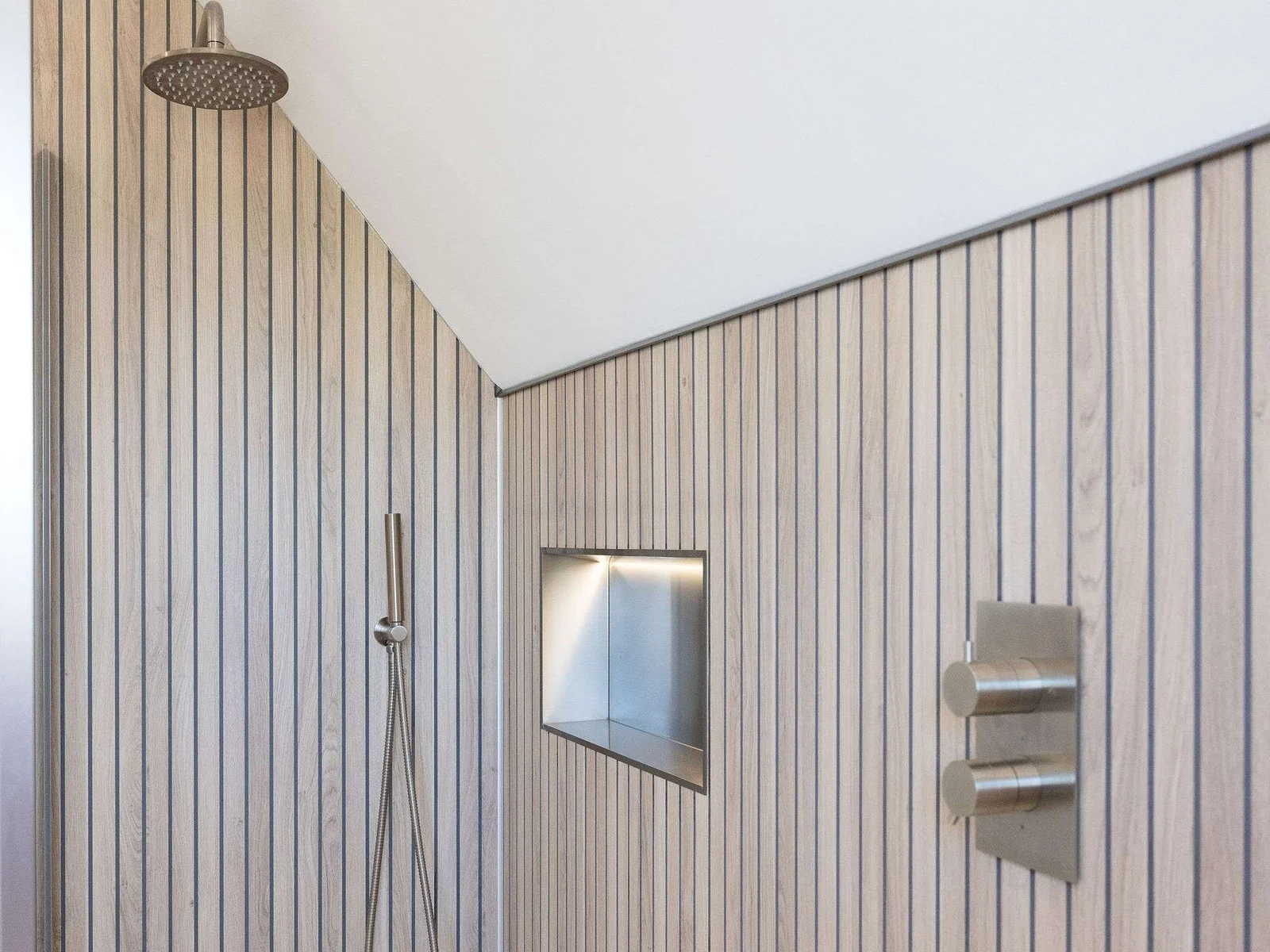 An easily accessible walk-in shower, with overhead and handheld shower heads.