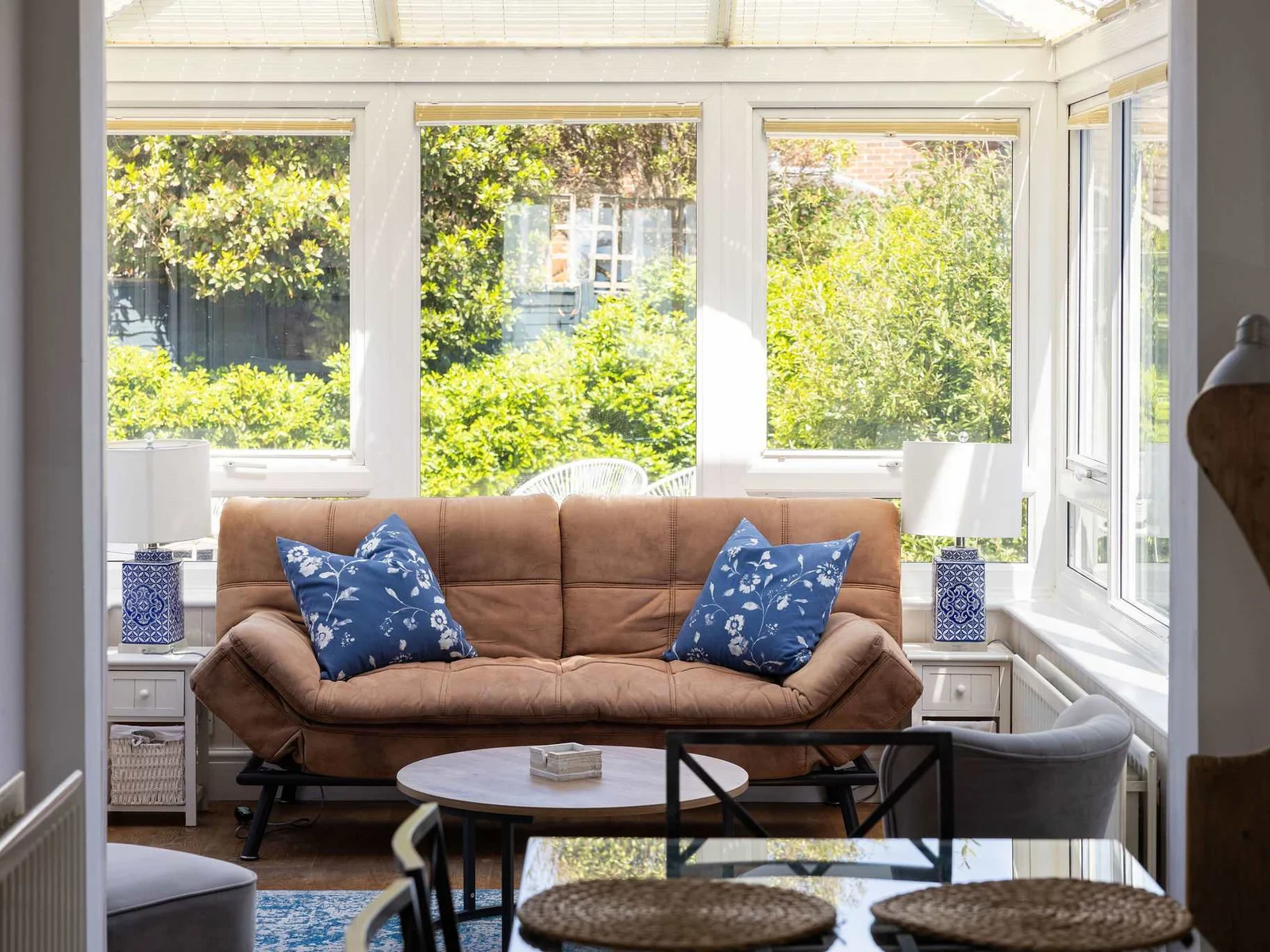 Bright conservatory with cosy seating, perfect for morning coffee and peaceful relaxation.