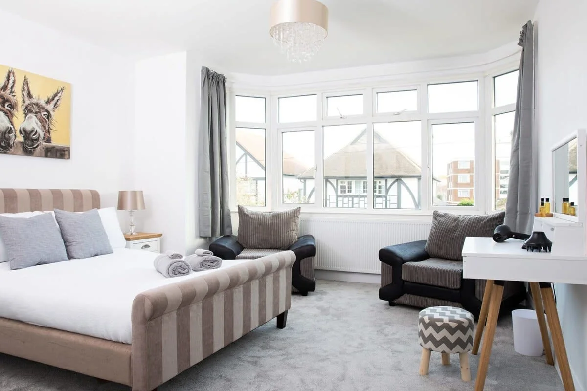 The light and airy Master Bedroom features 2 arm chairs and a beautiful sleigh bed