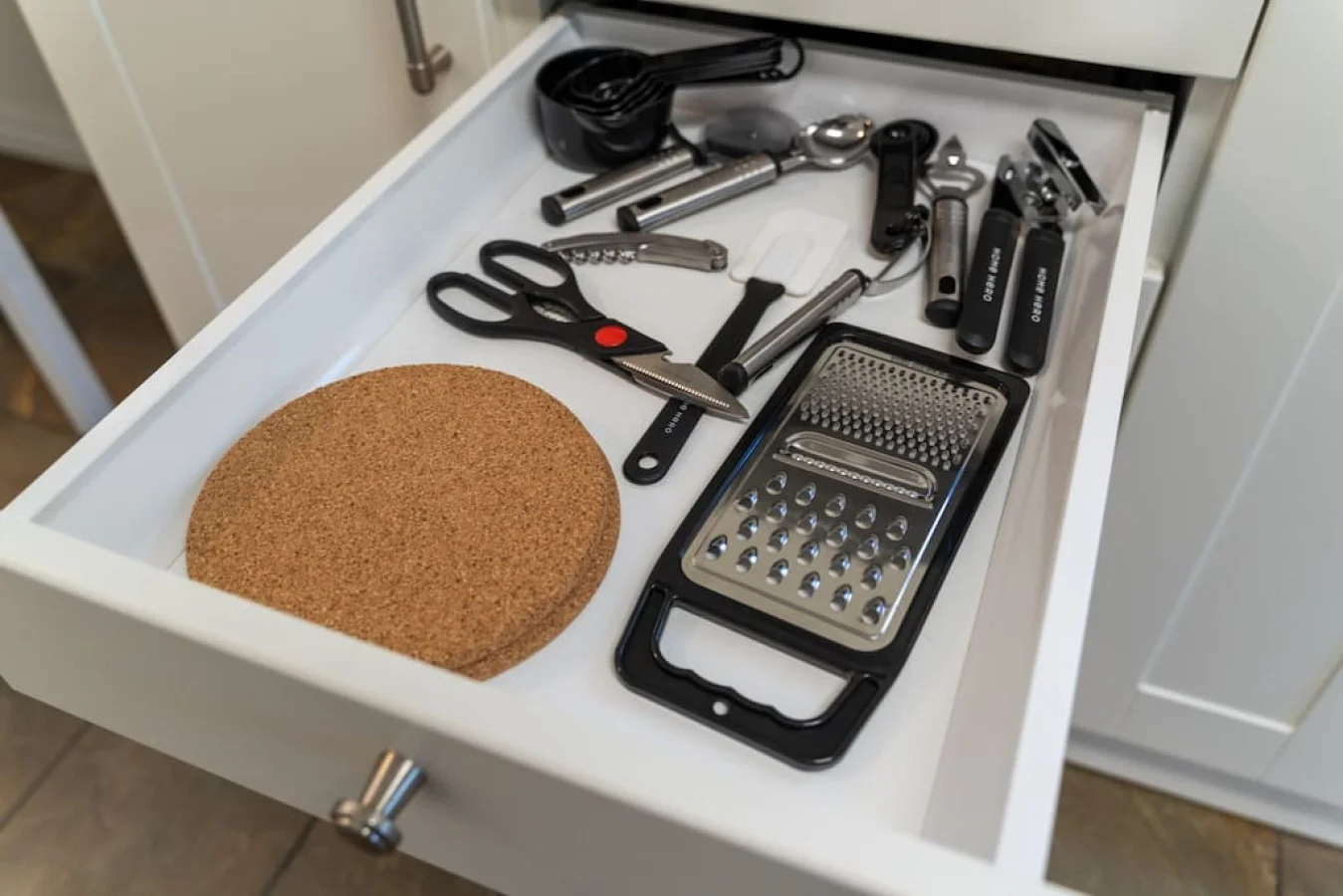 Kitchen utensils with scissors, measuring cups, grater, wine opener, can opener
