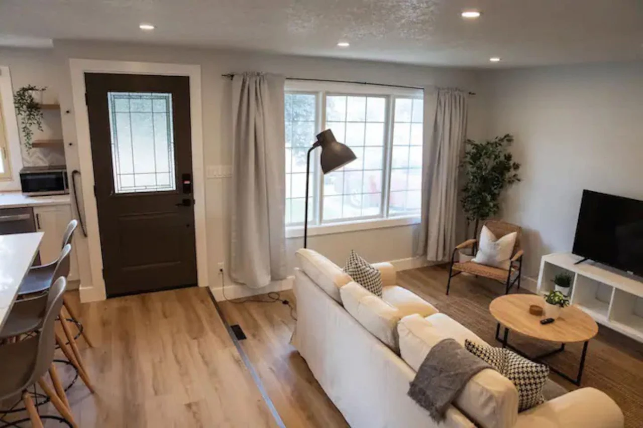 Spacious open-concept living and dining area featuring a vibrant sofa, modern furnishings, and a stylish entertainment setup—ideal for gatherings and relaxation.