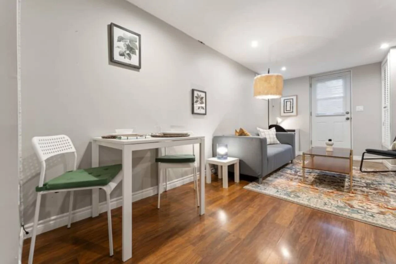 Spacious open-concept living and dining area featuring a vibrant sofa, modern furnishings, and a stylish entertainment setup—ideal for gatherings and relaxation.