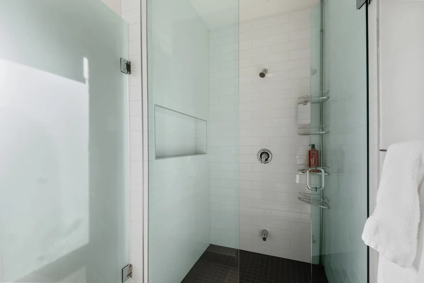 This bright and welcoming bathroom invites you to freshen up in comfort. Enjoy the forest-inspired shower curtain that adds a calming touch to your routine, complemented by the cozy rug underfoot and sparkling clean fixtures.