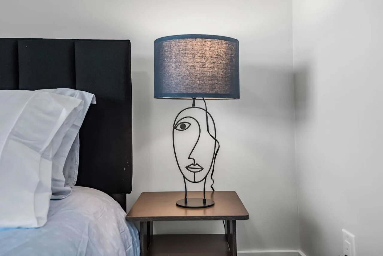 Cozy bedroom with bedside tables and lampsComfortable pillows with new sheetsDecorative pillows and throw