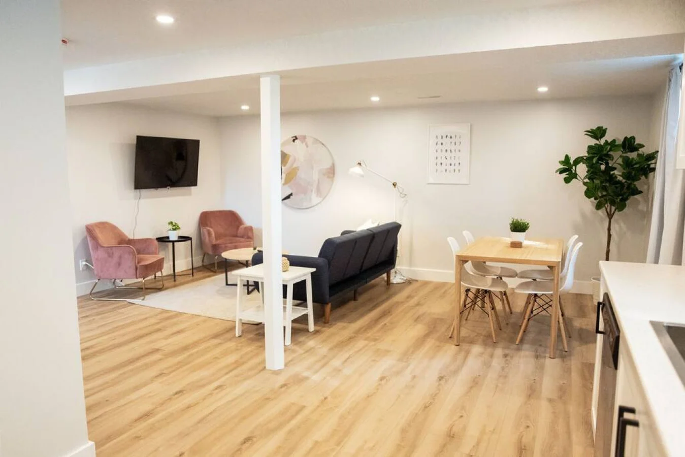 Spacious open-concept living and dining area featuring a vibrant sofa, modern furnishings, and a stylish entertainment setup—ideal for gatherings and relaxation.