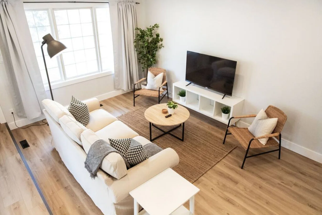 Bright and airy living room with plush seating, a large TV, and tasteful decor, creating the perfect space for relaxation and entertainment.