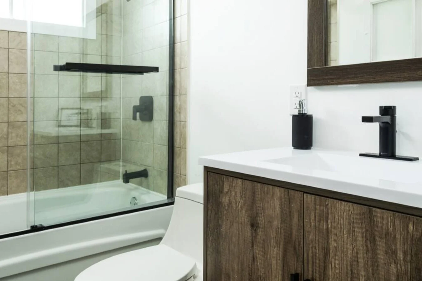 Modern bathroom with new glass shower door and black hardware