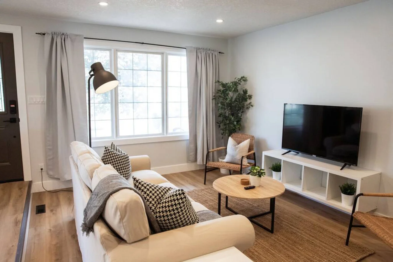 Bright and airy living room with plush seating, a large TV, and tasteful decor, creating the perfect space for relaxation and entertainment.