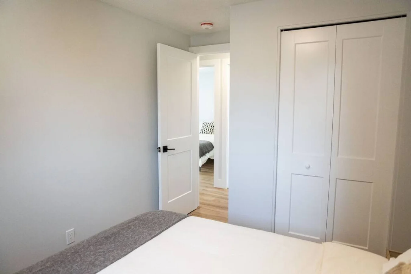 Tranquil bedroom with soft bedding and ample closet space, designed to ensure a restful night's sleep.