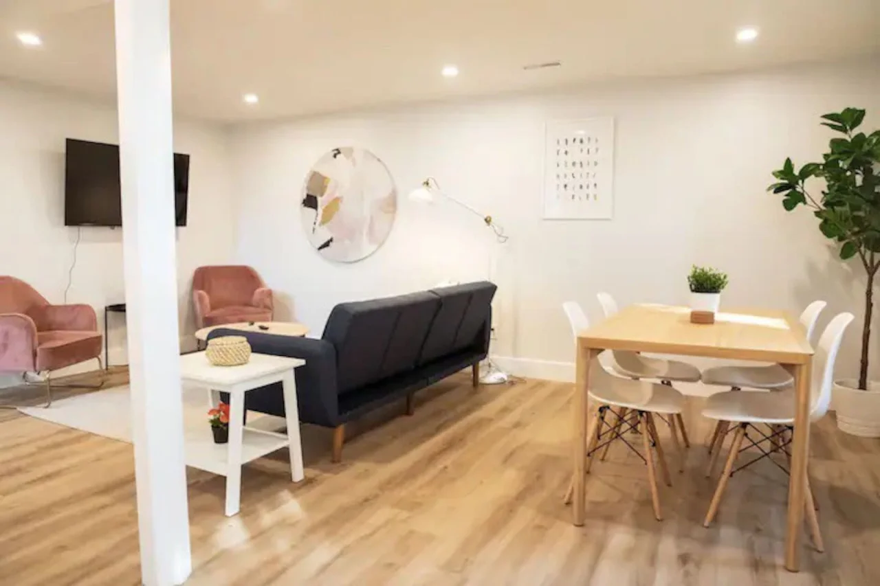 Spacious open-concept living and dining area featuring a vibrant sofa, modern furnishings, and a stylish entertainment setup—ideal for gatherings and relaxation.