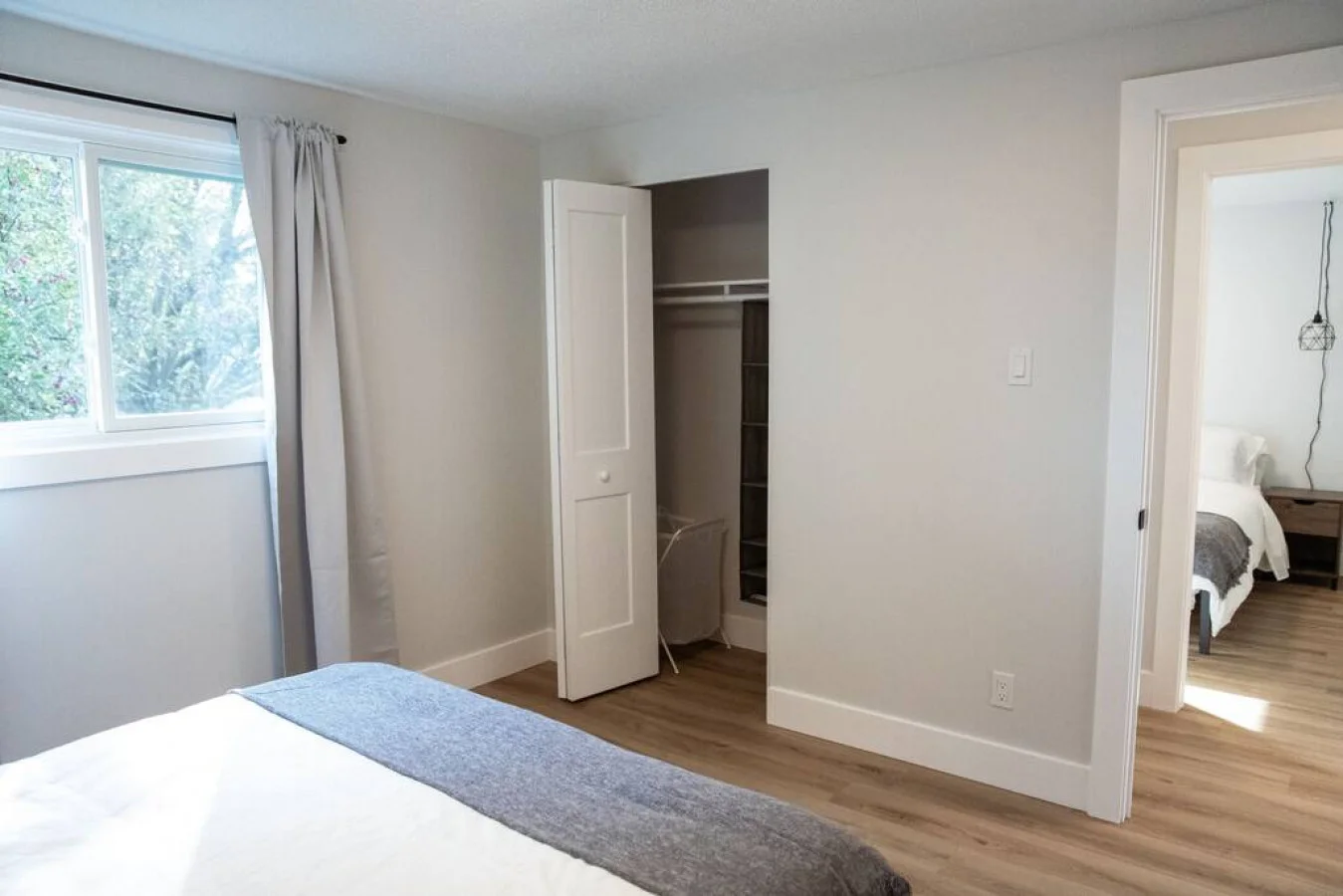 Tranquil bedroom with soft bedding and ample closet space, designed to ensure a restful night's sleep.