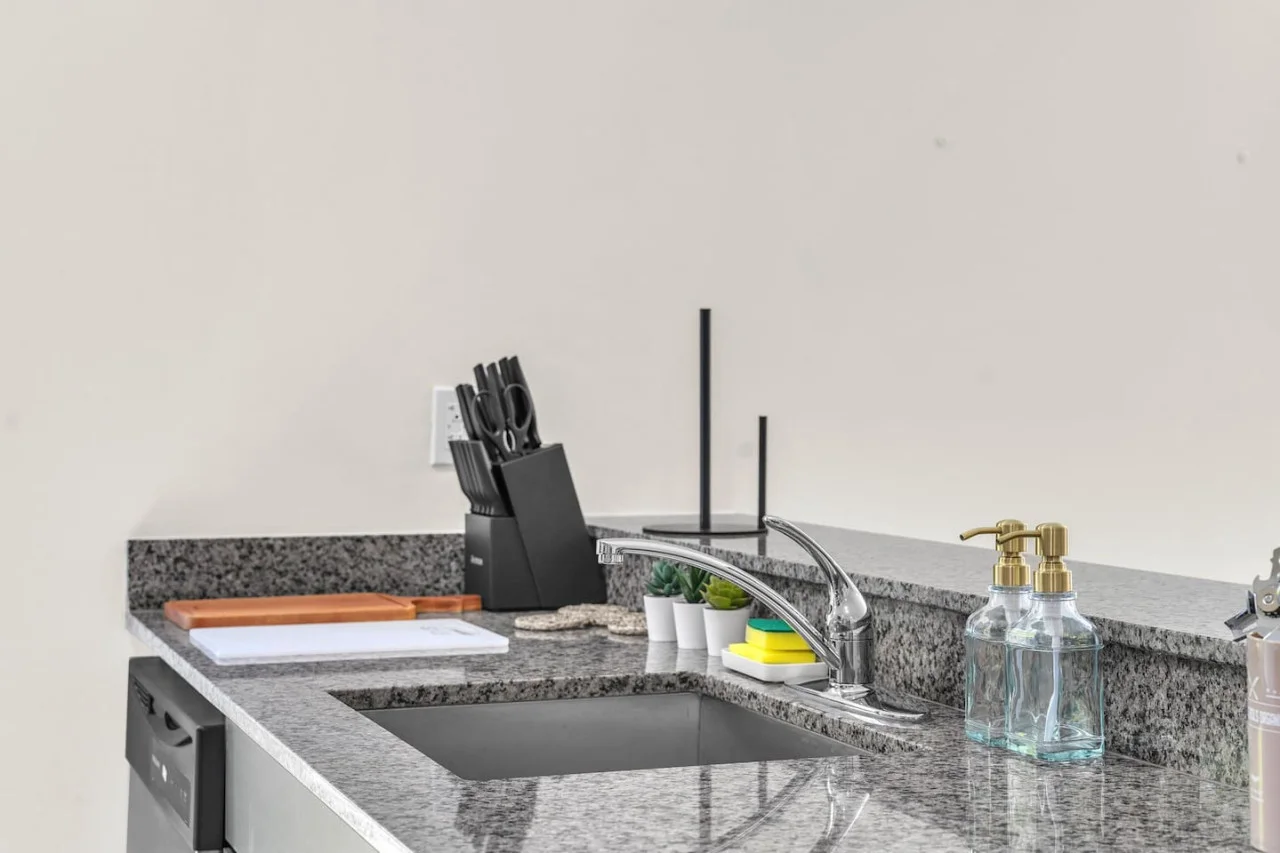 Granite countertop with a modern sink and knife set.