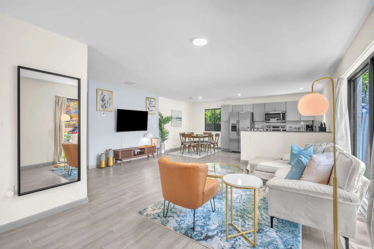 Stylish seating arrangement with a caramel accent chair, cozy throws, and a colorful area rug for a welcoming feel.