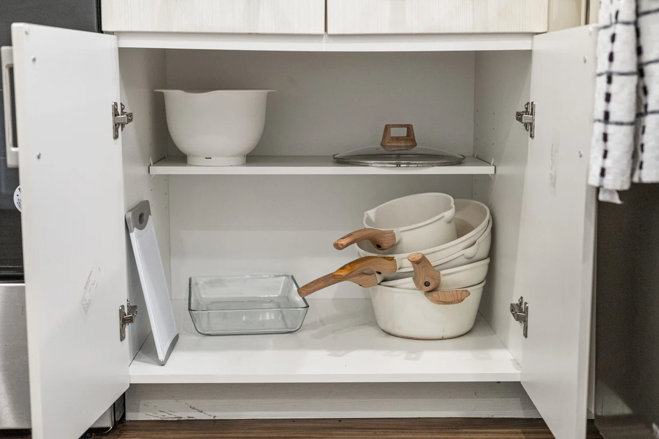 Well-stocked kitchen cabinets with quality cookware and essentials, thoughtfully organized for your convenience.