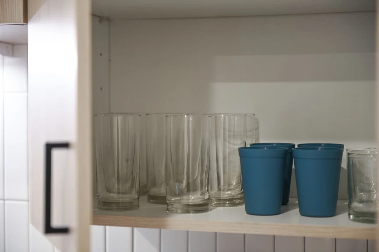 Kitchen cabinets stocked with cooking wares, glassware and silverwares, ideal for mixing up your favorite meals and drinks during your stay.