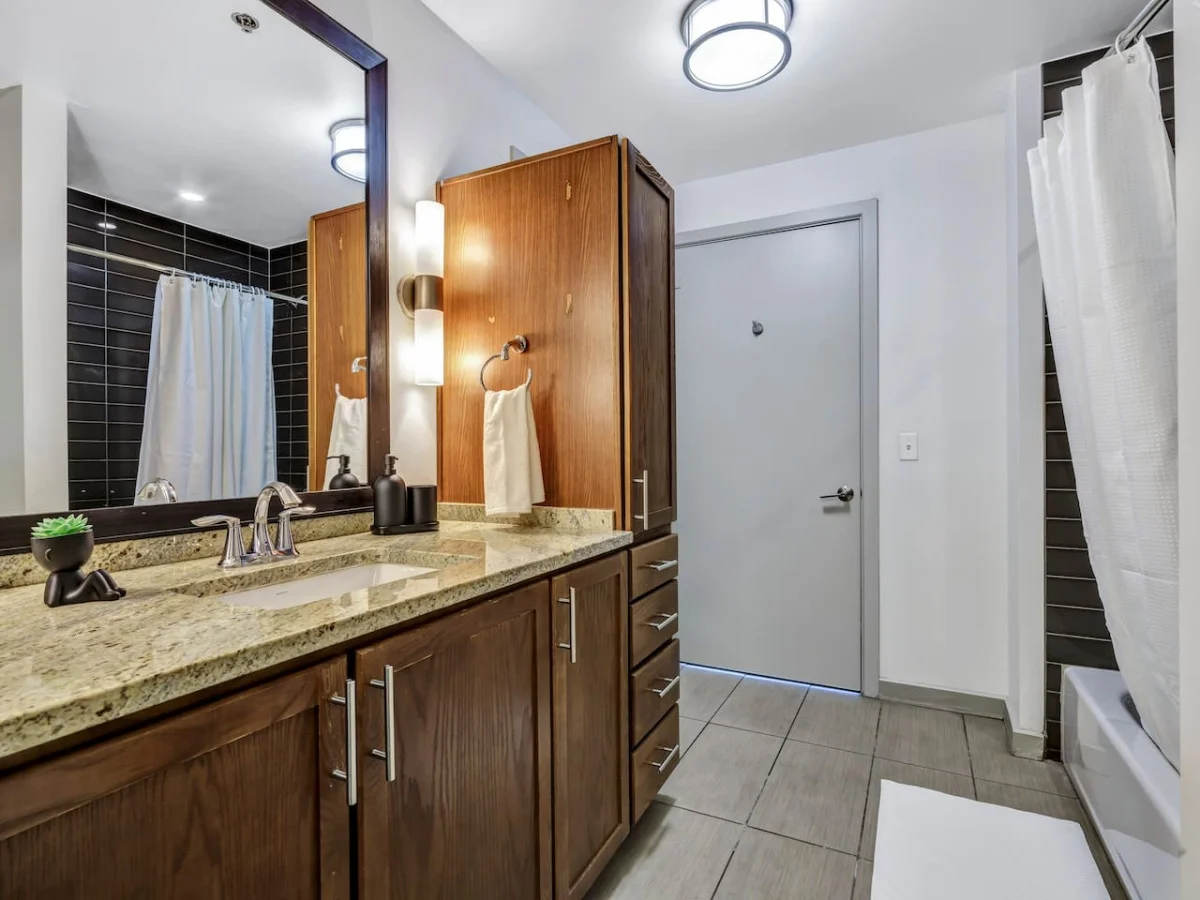 Immaculate bathroom featuring a spacious shower, fresh towels, and complimentary toiletries for a spa-like experience.