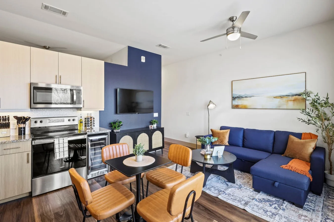 Spacious open-concept living and dining area featuring a vibrant sofa, modern furnishings, and a stylish entertainment setup—ideal for gatherings and relaxation.