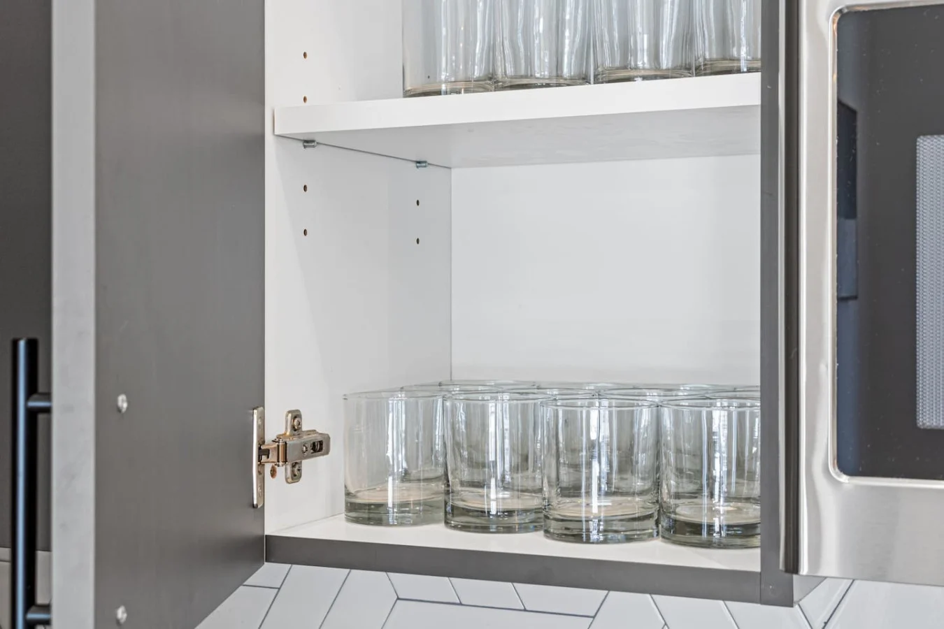 Kitchen cabinets stocked with cooking wares, glassware and silverwares, ideal for mixing up your favorite meals and drinks during your stay.