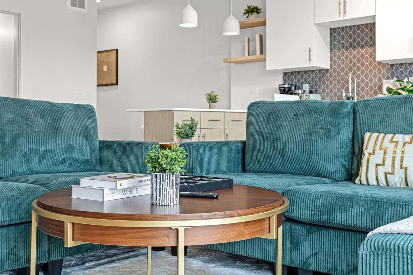 The living room’s plush seating beckons you to sink in and relax, surrounded by light and airy decor.