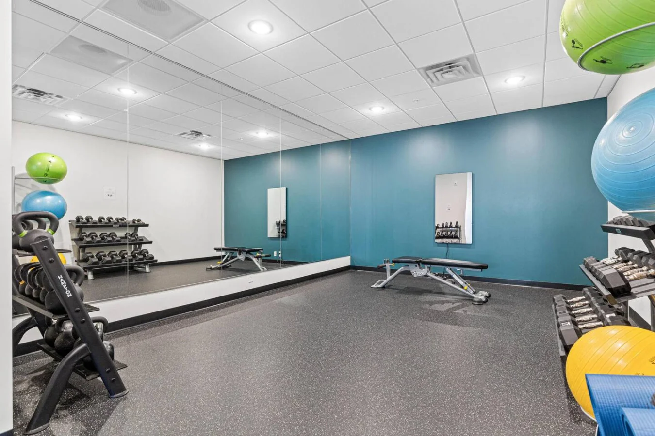 Open floor area with exercise mats, yoga balls, and foam rollers for warm-ups, stretching, or core exercises.