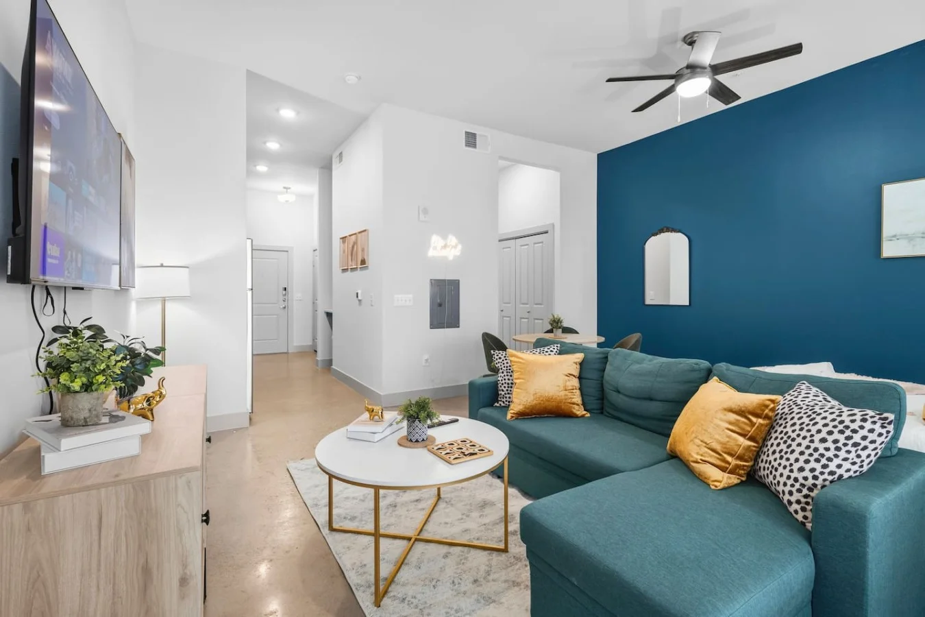"Stylish open-concept living space featuring a bold blue accent wall and plush, comfortable seating."
