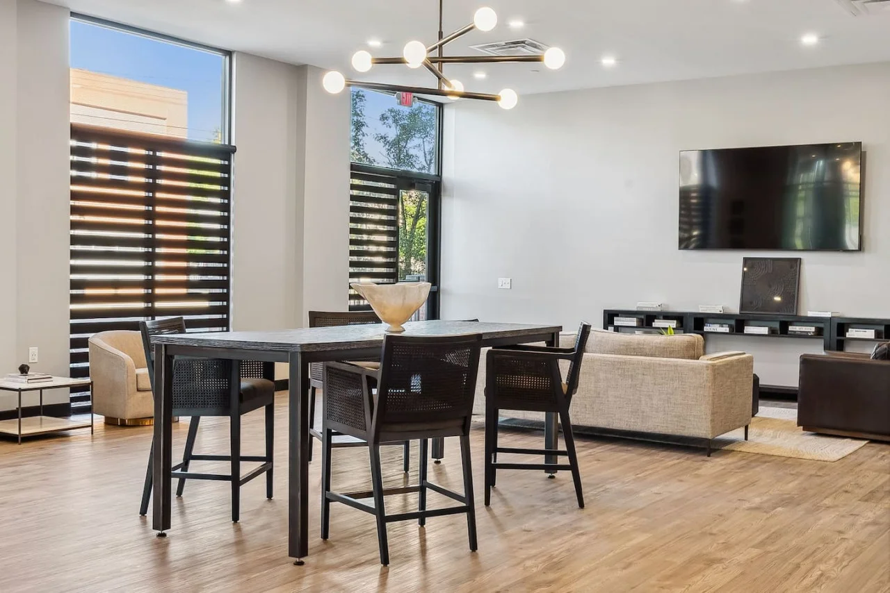 Spacious open-concept living and dining area featuring a vibrant sofa, modern furnishings, and a stylish entertainment setup—ideal for gatherings and relaxation.