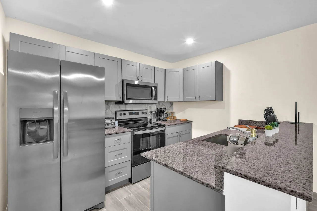 Cook with ease in this well-equipped kitchen featuring stainless steel appliances, ample cabinetry, and a stylish backsplash. Whether you're brewing coffee or preparing a gourmet meal, this space is designed for functionality and style, making every meal