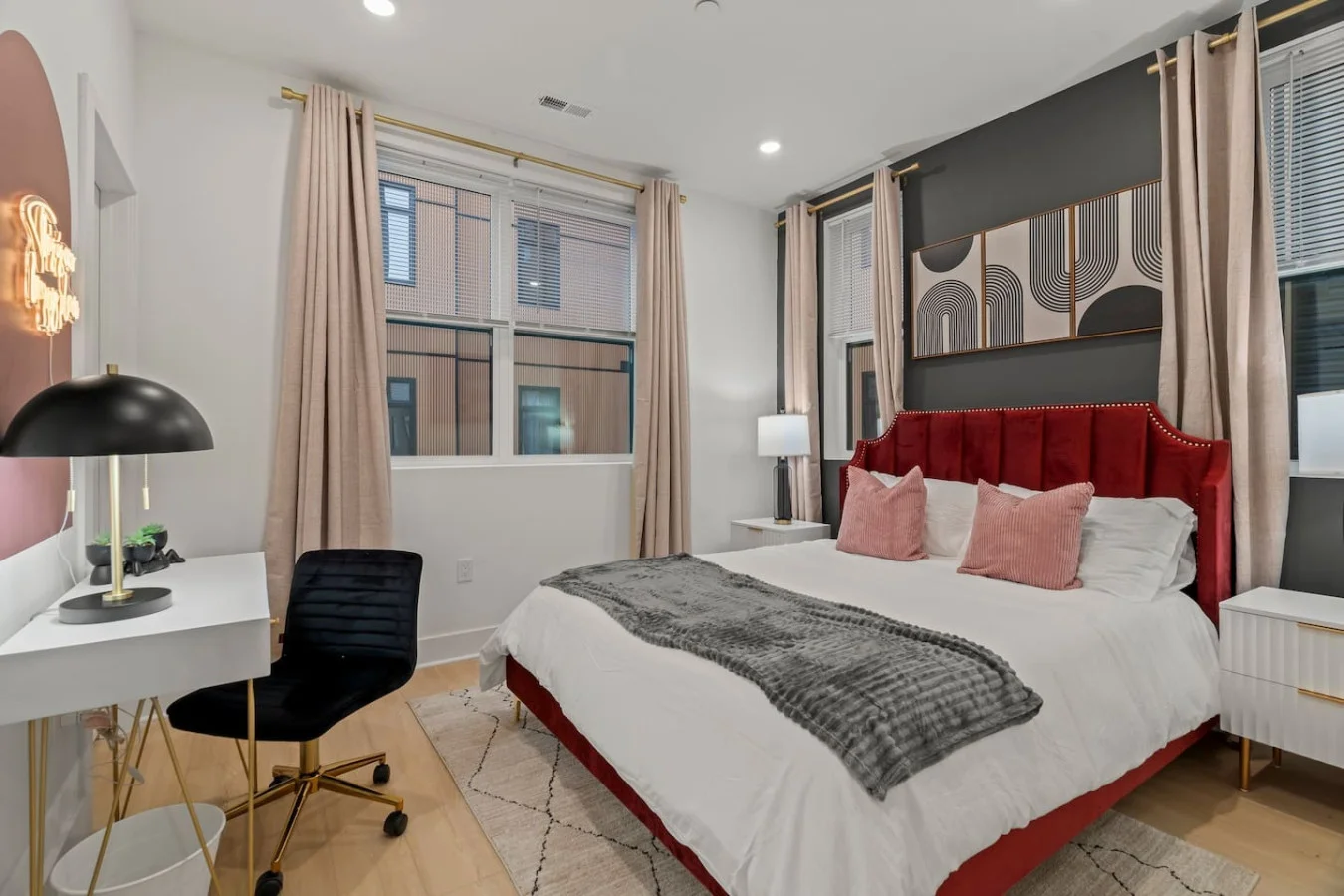 Luxe Bedroom with Queen Bed, Side Tables, Table Lamps, and Work Space. Corner room with plenty of natural light. Windows treated with blinds and blackout curtains for a restful sleep.