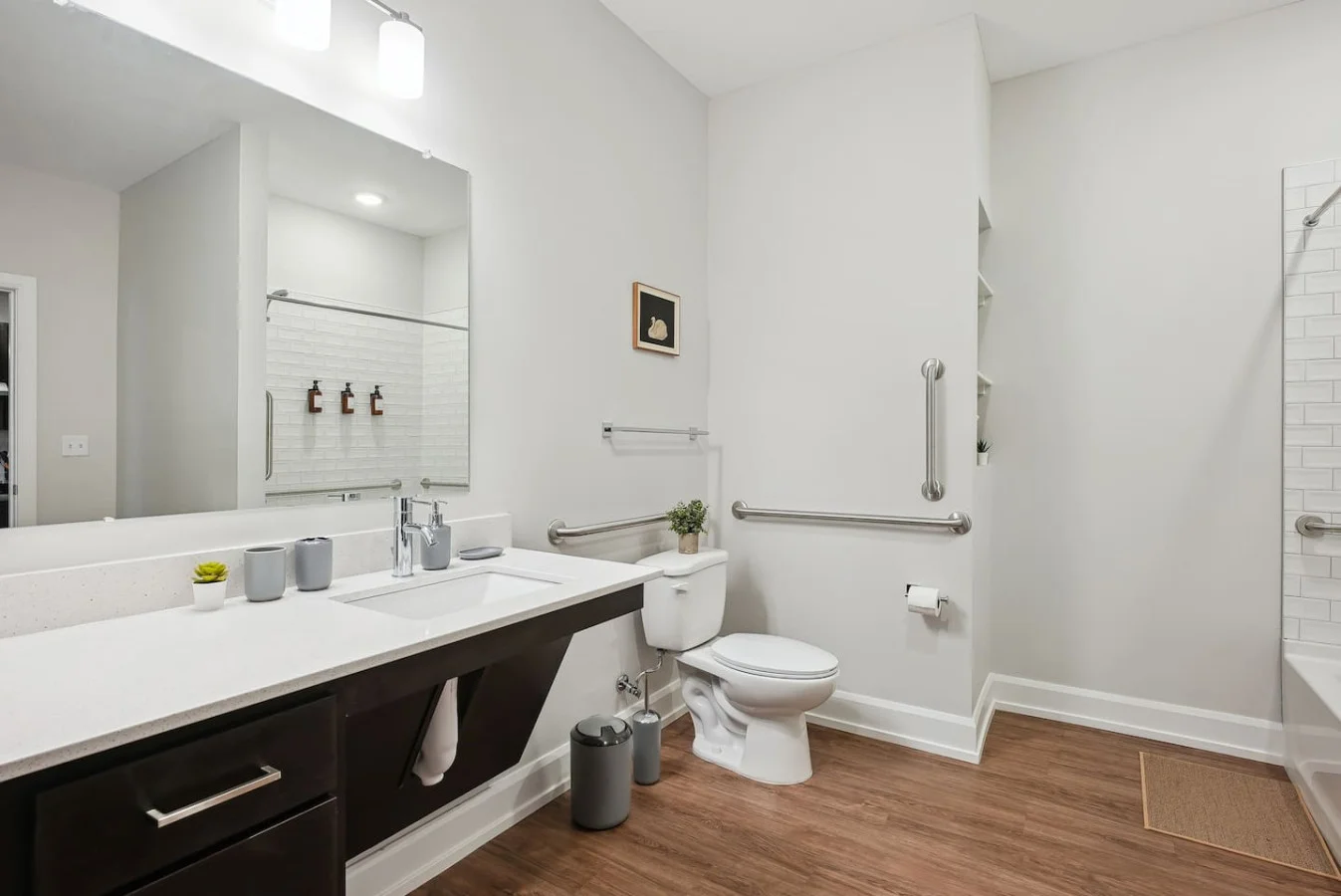 This bright and welcoming bathroom invites you to freshen up in comfort. Enjoy the forest-inspired shower curtain that adds a calming touch to your routine, complemented by the cozy rug underfoot and sparkling clean fixtures.