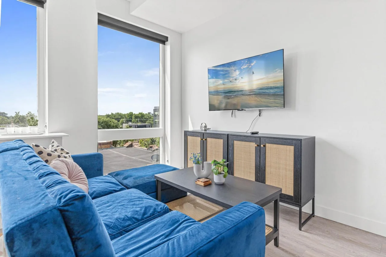 Bright and airy living room with plush seating, a large TV, and tasteful decor, creating the perfect space for relaxation and entertainment.