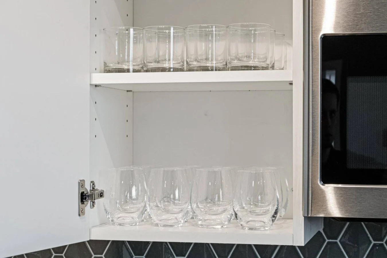 Kitchen cabinets stocked with cooking wares, glassware and silverwares, ideal for mixing up your favorite meals and drinks during your stay.