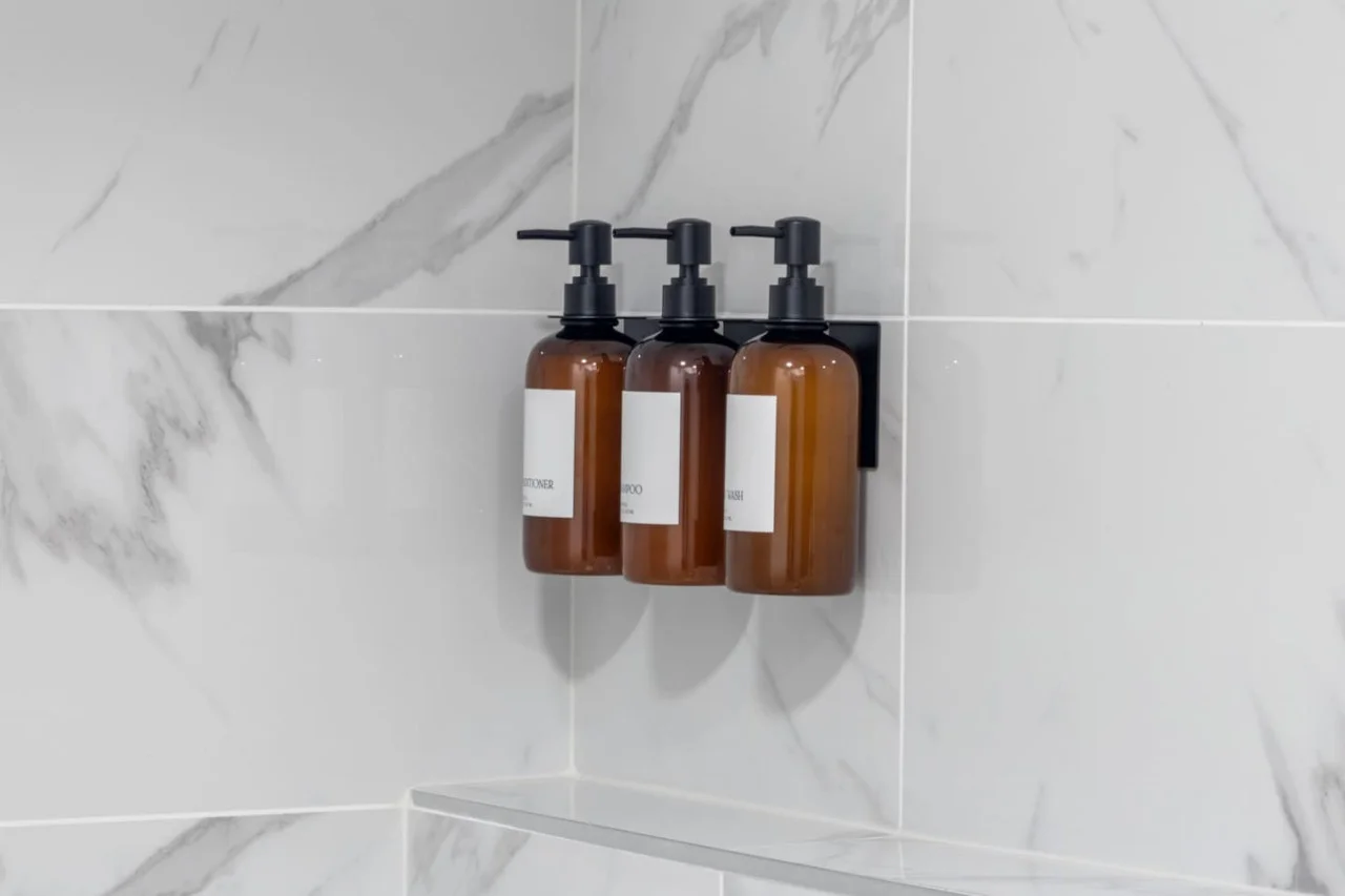 Immaculate bathroom featuring a spacious shower, fresh towels, and complimentary toiletries for a spa-like experience.