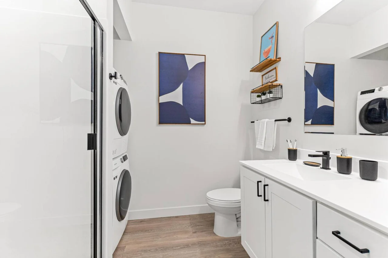 This bright and welcoming bathroom invites you to freshen up in comfort. Enjoy the forest-inspired shower curtain that adds a calming touch to your routine, complemented by the cozy rug underfoot and sparkling clean fixtures.