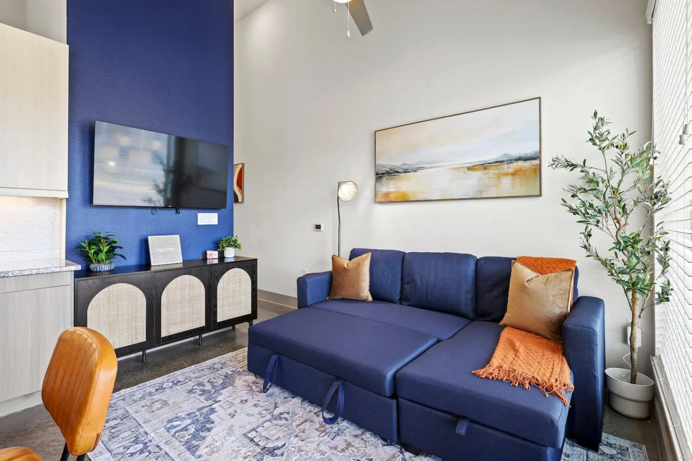The living room’s plush seating beckons you to sink in and relax, surrounded by light and airy decor.