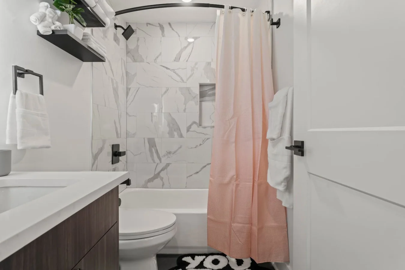 Modern bathroom with shower curtains and essentials provided (high quality linens, hairdryer, toilet paper)