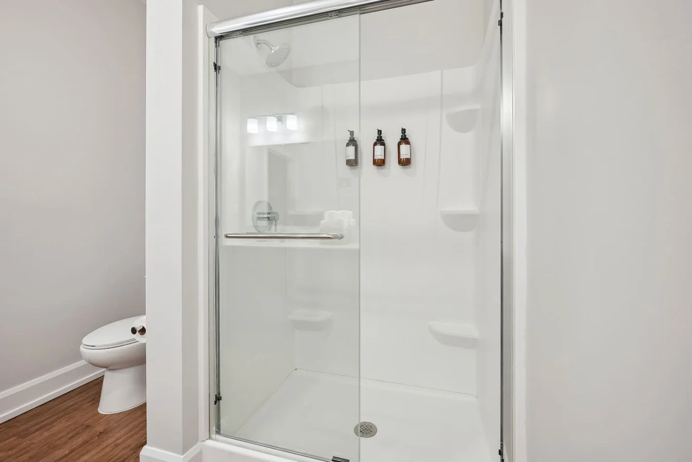 This bright and welcoming bathroom invites you to freshen up in comfort. Enjoy the forest-inspired shower curtain that adds a calming touch to your routine, complemented by the cozy rug underfoot and sparkling clean fixtures.