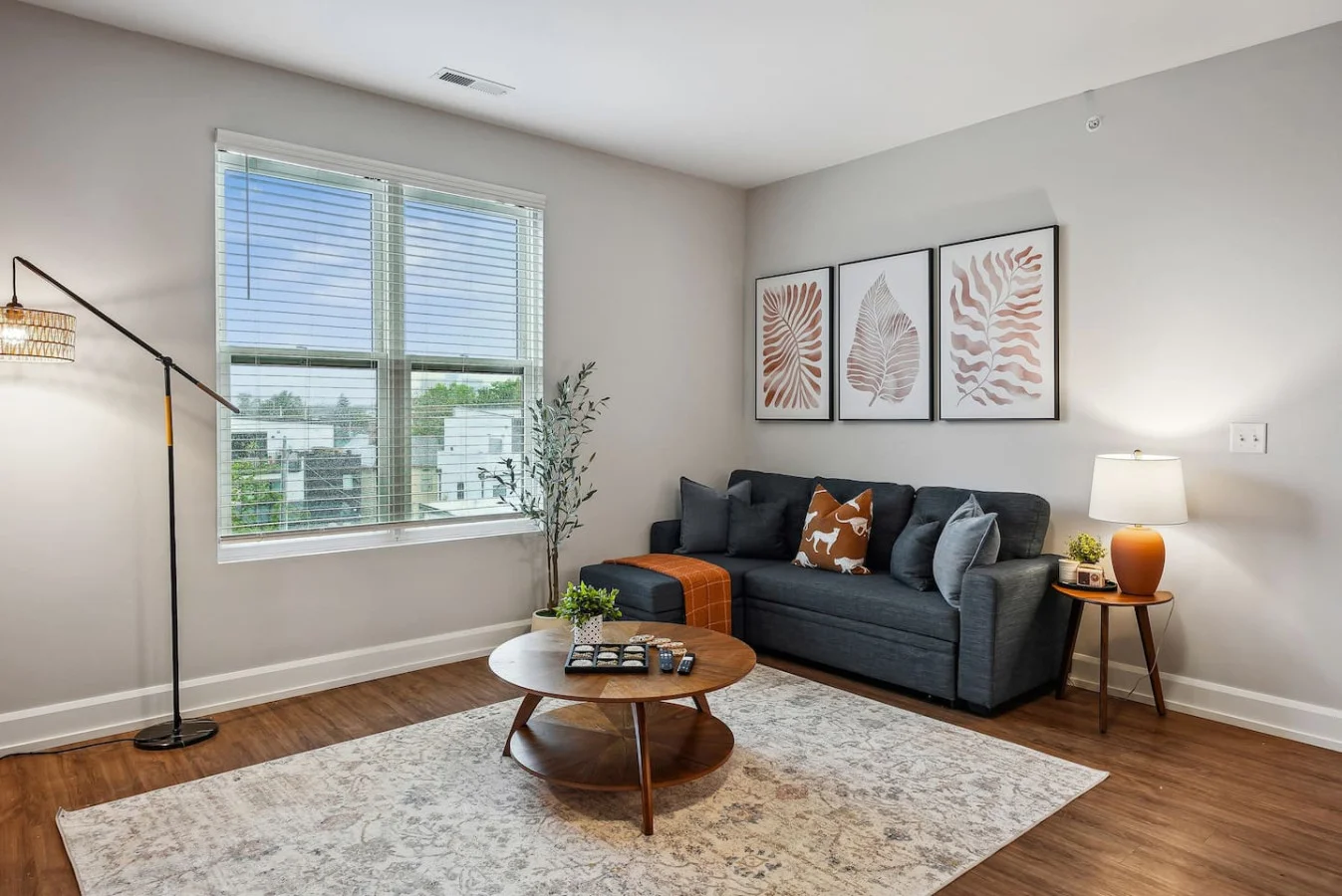 The living room’s plush seating beckons you to sink in and relax, surrounded by light and airy decor.