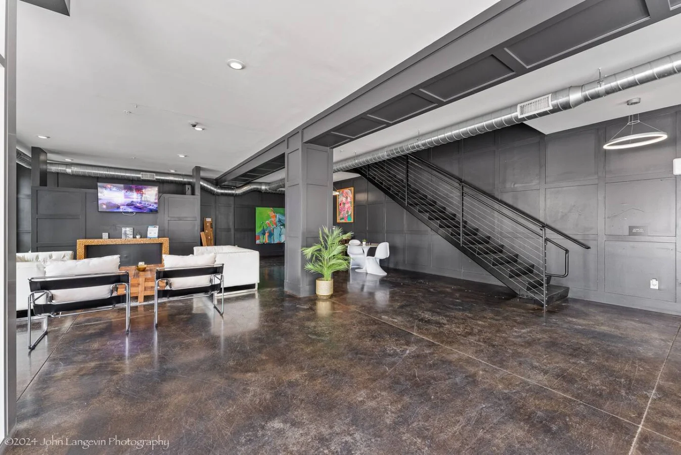 Enjoy a stylish and welcoming living space featuring modern decor and a large flat-screen TV. The unique mirror reflects the vibrant "Good Vibes Only" sign, adding a playful touch to the ambiance. Perfect for relaxation and entertainment.