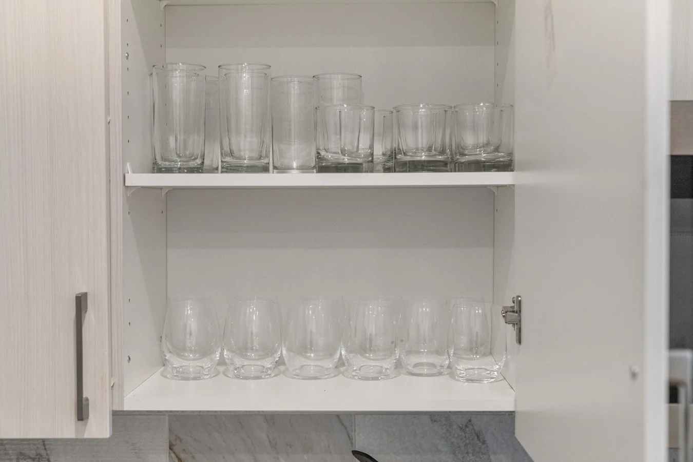 Thoughtfully organized kitchen cabinet with a selection of glassware for your convenience.