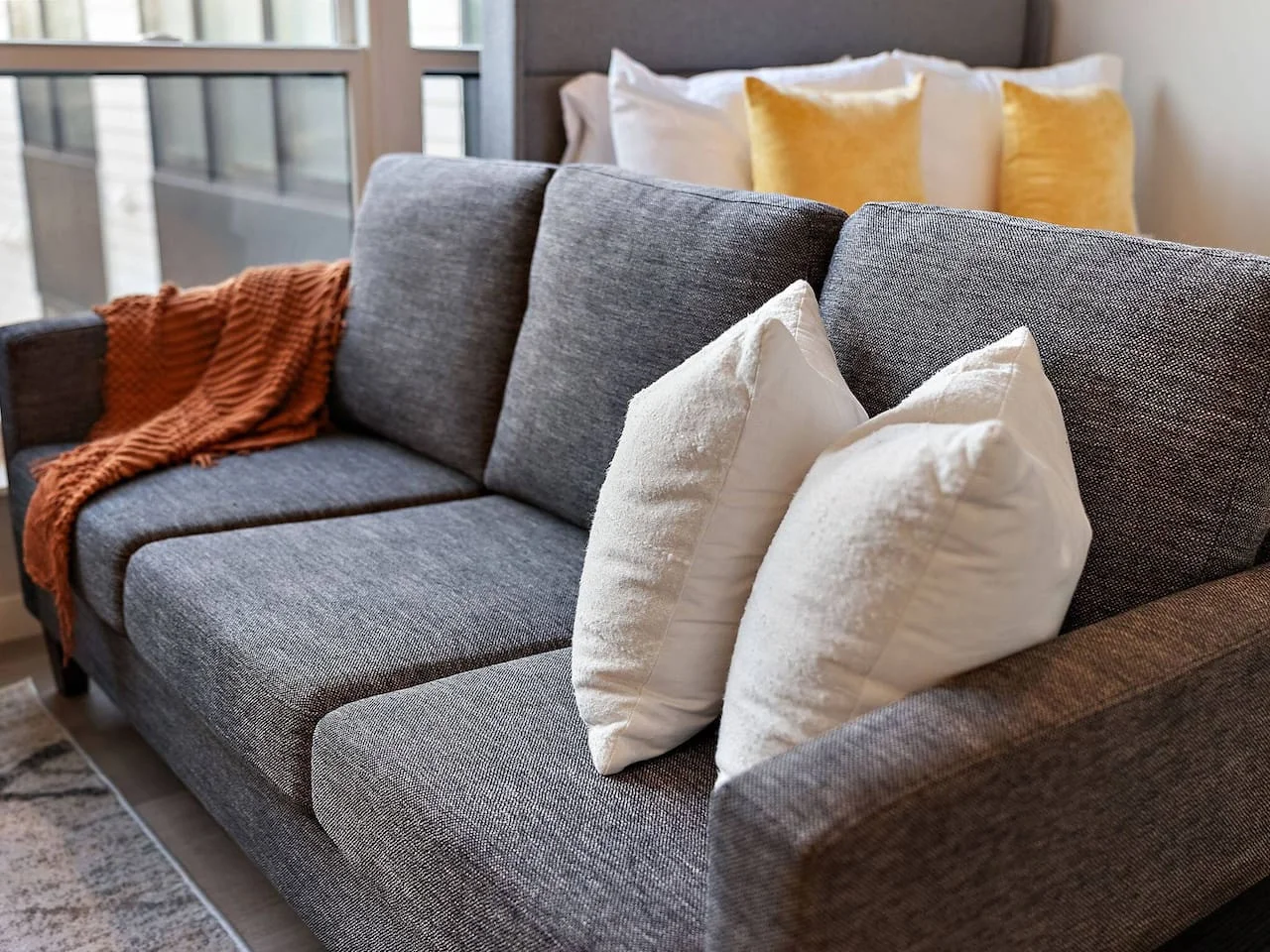 The living room’s plush seating beckons you to sink in and relax, surrounded by light and airy decor.