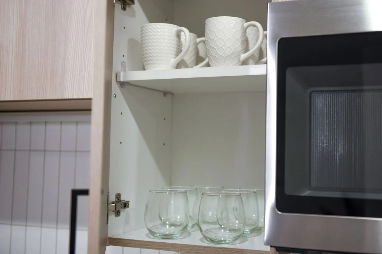 Kitchen cabinets stocked with cooking wares, glassware and silverwares, ideal for mixing up your favorite meals and drinks during your stay.