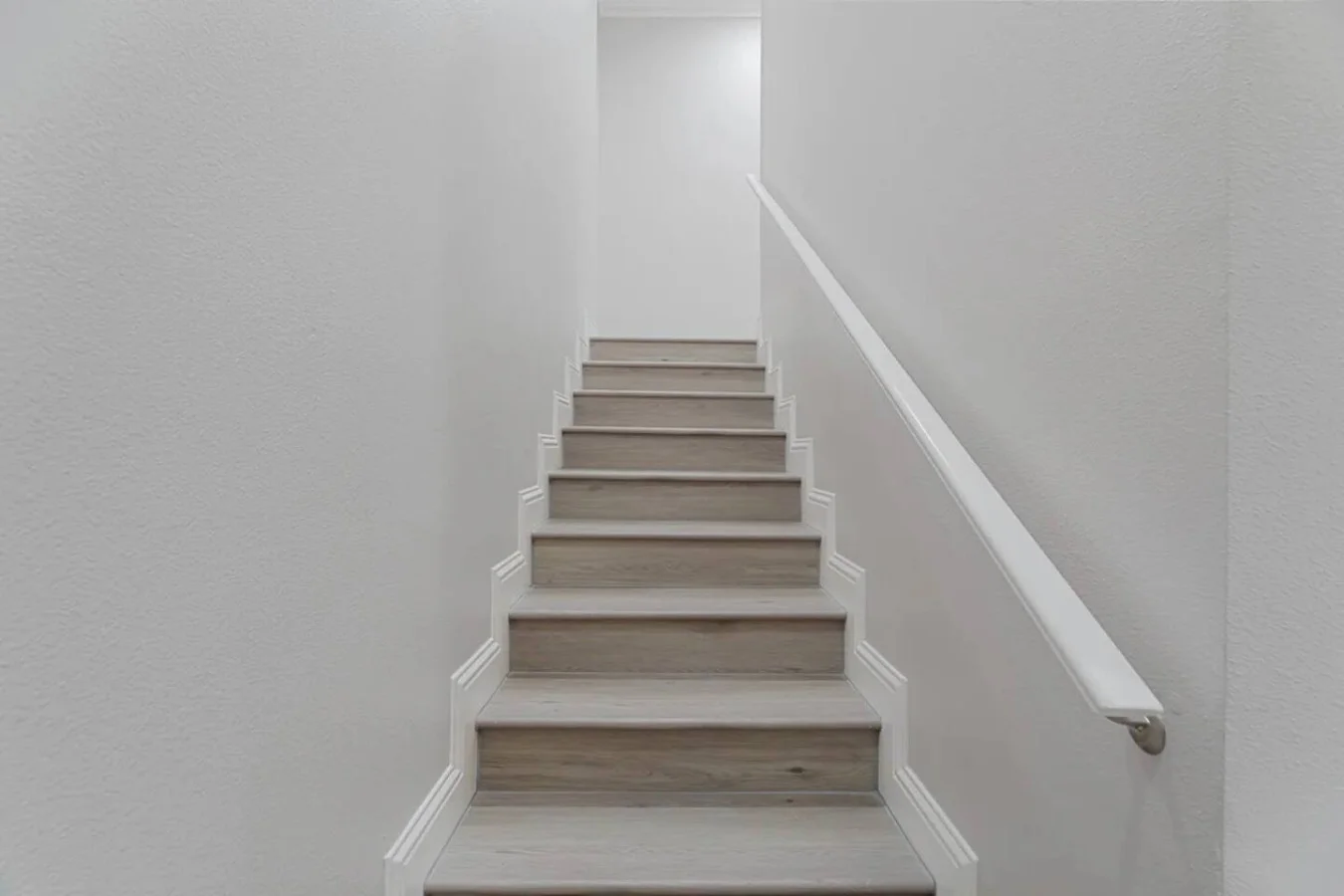 The staircase is a focal point of the home, with its graceful lines and stylish details adding to the overall charm.