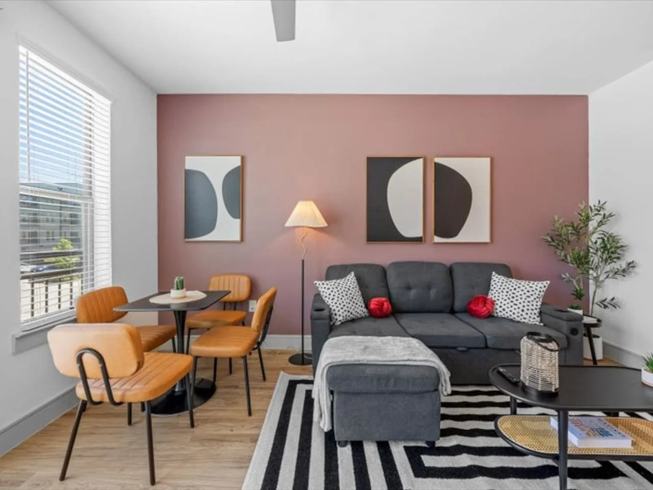 Spacious open-concept living and dining area featuring a vibrant sofa, modern furnishings, and a stylish entertainment setup—ideal for gatherings and relaxation.