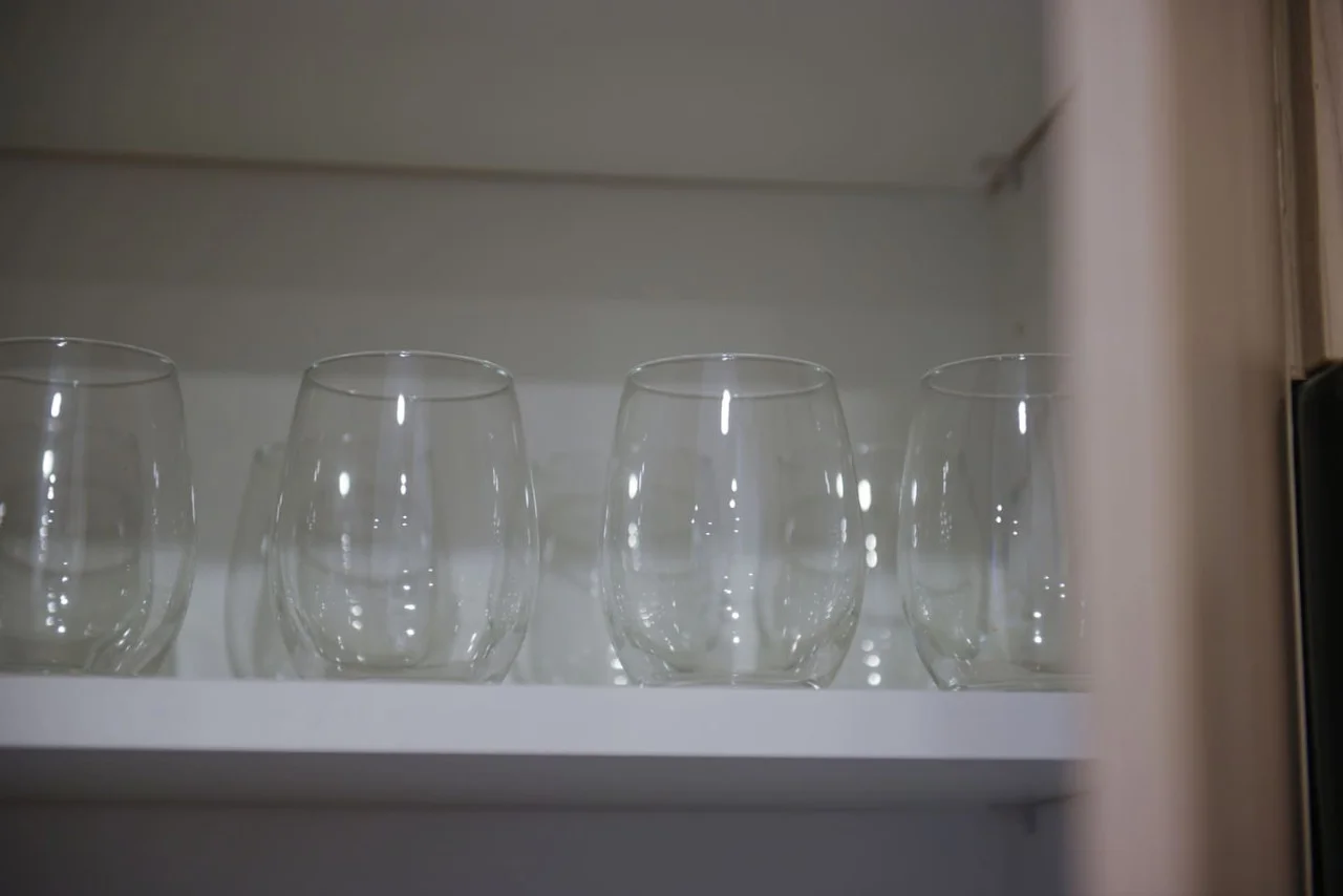 Kitchen cabinets stocked with cooking wares, glassware and silverwares, ideal for mixing up your favorite meals and drinks during your stay.