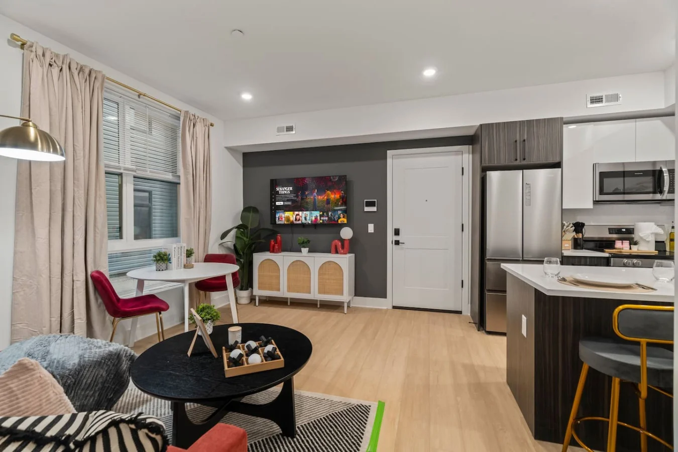 Bright and modern living space with a 55" Smart TV, dining area, and a fully equipped kitchen for comfort and convenience.